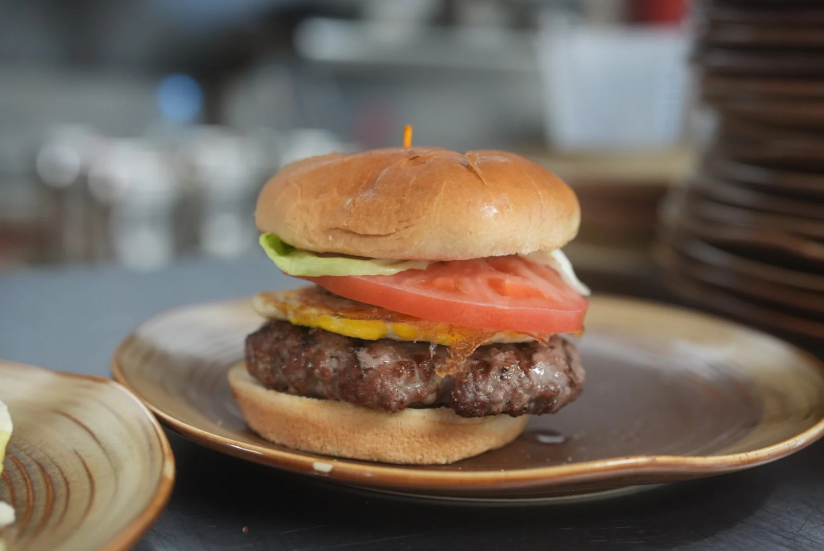 Cheeseburger with tomato and lettuce on a brioche bun