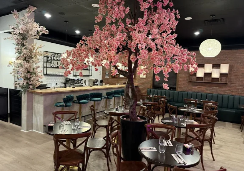 Morning Bloom interior with a large pink blossom tree, bar seating, green booths and pendant lights